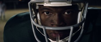 Movie still from “Woodlawn” (2015), directed by Jon Erwin – A person wearing a football helmet; Extreme Close Up shot, Low angle