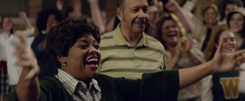 Movie still from “Woodlawn” (2015), directed by Jon Erwin – A group of people sitting in a room; Close Up shot, Over the shoulder angle