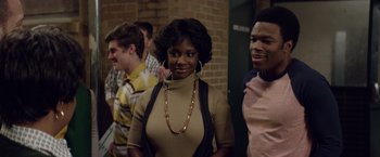 Movie still from “Woodlawn” (2015), directed by Jon Erwin – A group of people standing next to each other in a room; Medium shot, Over the shoulder angle