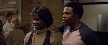 Movie still from “Woodlawn” (2015), directed by Jon Erwin – A woman standing next to a man in front of a brick wall; Close Up shot, Over the shoulder angle
