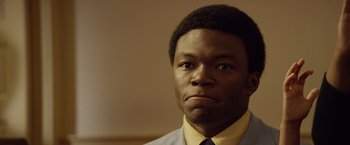 Movie still from “Woodlawn” (2015), directed by Jon Erwin – A person wearing a suit and tie; Close Up shot, Low angle