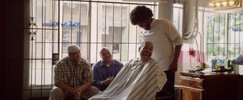 Movie still from “Woodlawn” (2015), directed by Jon Erwin – A man getting a haircut in a barber shop; Medium shot, Over the shoulder angle