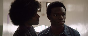Movie still from “Woodlawn” (2015), directed by Jon Erwin – Two men standing next to each other in front of a window; Close Up shot, Over the shoulder angle