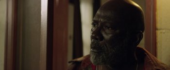 Movie still from “Woodlawn” (2015), directed by Jon Erwin – An older man with a beard looking into the distance; Close Up shot, High angle