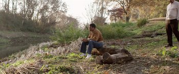 Movie still from “Woodlawn” (2015), directed by Jon Erwin – A man sitting on top of a tree stump; Wide shot, High angle