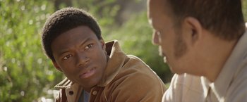 Movie still from “Woodlawn” (2015), directed by Jon Erwin – Two men are talking to each other in a park; Close Up shot, Over the shoulder angle