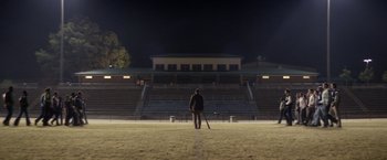 Movie still from “Woodlawn” (2015), directed by Jon Erwin – A man standing on a baseball field holding a baseball bat; Extreme Wide shot, Low angle