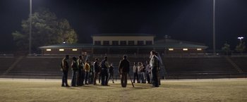 Movie still from “Woodlawn” (2015), directed by Jon Erwin – A group of people standing on top of a baseball field at night; Extreme Wide shot, High angle