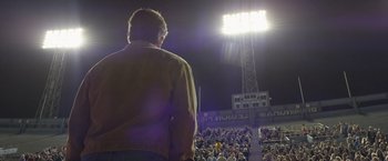 Movie still from “Woodlawn” (2015), directed by Jon Erwin – A man standing in front of a crowd of people; Medium shot, Low angle