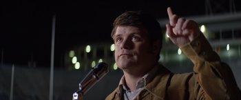 Movie still from “Woodlawn” (2015), directed by Jon Erwin – A man is speaking into a microphone at a political event; Close Up shot, Low angle