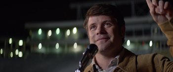 Movie still from “Woodlawn” (2015), directed by Jon Erwin – A person holding a microphone; Close Up shot, Low angle