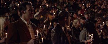 Movie still from “Woodlawn” (2015), directed by Jon Erwin – A group of people holding lit candles in a crowd of people; Medium shot, Over the shoulder angle