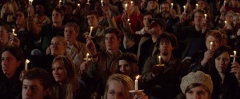 Movie still from “Woodlawn” (2015), directed by Jon Erwin – A group of people holding lit candles in the dark; Medium shot, High angle