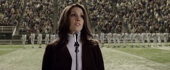 Movie still from “Woodlawn” (2015), directed by Jon Erwin – A woman is speaking into a microphone in front of a crowd; Close Up shot, Low angle