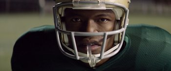 Movie still from “Woodlawn” (2015), directed by Jon Erwin – A person wearing a football helmet; Extreme Close Up shot, Low angle
