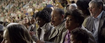 Movie still from “Woodlawn” (2015), directed by Jon Erwin – A group of people sitting in a crowd at a sporting event; Close Up shot, Over the shoulder angle