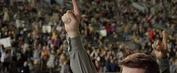 Movie still from “Woodlawn” (2015), directed by Jon Erwin – A person raising their hand in front of an audience; Medium shot, Low angle