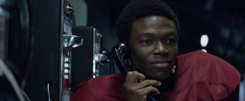 Movie still from “Woodlawn” (2015), directed by Jon Erwin – A man holding a phone up to his ear; Close Up shot, Low angle