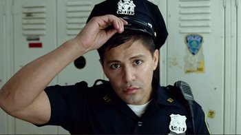 Movie still from “World Trade Center” (2006), directed by Oliver Stone – A man in a police officer's uniform adjusts his hat; Close Up shot, Low angle