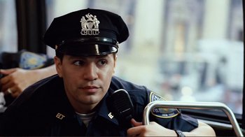 Movie still from “World Trade Center” (2006), directed by Oliver Stone – A police officer is holding a walkie talkie in his hand; Close Up shot, Low angle