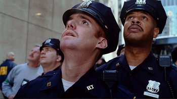 Movie still from “World Trade Center” (2006), directed by Oliver Stone – A group of men in police uniforms looking upward; Close Up shot, Low angle