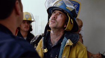 Movie still from “World Trade Center” (2006), directed by Oliver Stone – A man in a fireman's uniform with a helmet on his head looking up; Close Up shot, Low angle