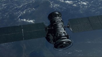 Movie still from “World Trade Center” (2006), directed by Oliver Stone – An image of a satellite in the sky above the earth; Extreme Wide shot, Overhead angle