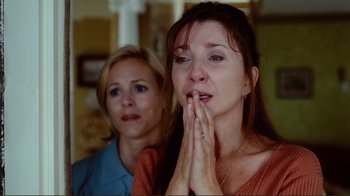 Movie still from “World Trade Center” (2006), directed by Oliver Stone – Two women sitting in front of each other with their eyes closed; Close Up shot, Over the shoulder angle