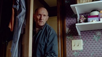 Movie still from “World Trade Center” (2006), directed by Oliver Stone – An older man standing in front of a bathroom mirror; Medium shot, Over the shoulder angle