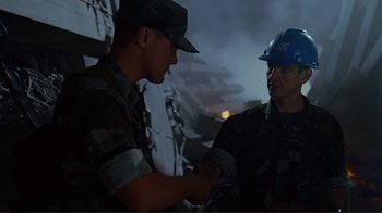 Movie still from “World Trade Center” (2006), directed by Oliver Stone – Two men in fatigues and hard hats shaking hands; Medium shot, Over the shoulder angle