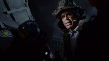 Movie still from “World Trade Center” (2006), directed by Oliver Stone – A man in a fireman's hat is standing in front of a building; Close Up shot, Low angle