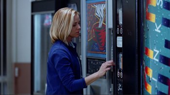 Movie still from “World Trade Center” (2006), directed by Oliver Stone – A woman in a blue jacket is looking at a vending machine; Medium shot, Low angle