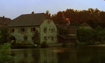 Movie still from “Woyzeck” (1979), directed by Werner Herzog – An old house on the side of a river; Extreme Wide shot, High angle