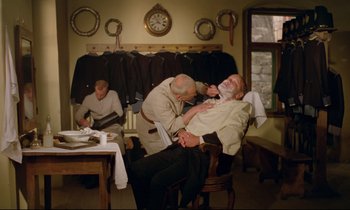 Movie still from “Woyzeck” (1979), directed by Werner Herzog – A man getting his teeth brushed by another man; Medium shot, Over the shoulder angle