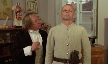 Movie still from “Woyzeck” (1979), directed by Werner Herzog – Two men in historical clothing looking up at one another; Medium shot, Low angle