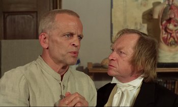 Movie still from “Woyzeck” (1979), directed by Werner Herzog – A man and a man wearing a suit and tie; Close Up shot, Over the shoulder angle