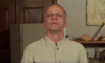 Movie still from “Woyzeck” (1979), directed by Werner Herzog – A bald man with a goatee is looking upward; Close Up shot, Low angle