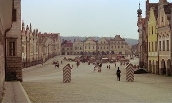 Movie still from “Woyzeck” (1979), directed by Werner Herzog – People are walking in the sand in front of buildings; Extreme Wide shot, High angle