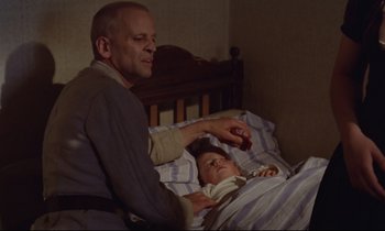 Movie still from “Woyzeck” (1979), directed by Werner Herzog – An older man and a young child in bed; Medium shot, High angle