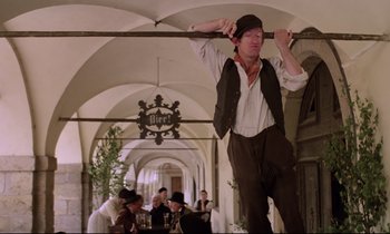 Movie still from “Woyzeck” (1979), directed by Werner Herzog – A man hanging from the ceiling of a building; Medium shot, Low angle