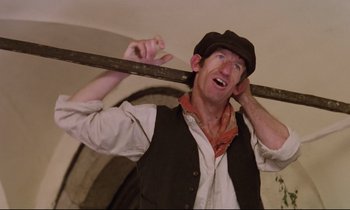 Movie still from “Woyzeck” (1979), directed by Werner Herzog – A man holding a wooden stick in his hands; Close Up shot, Low angle