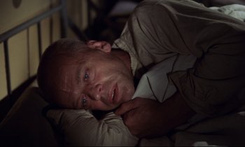 Movie still from “Woyzeck” (1979), directed by Werner Herzog – A person laying in a bed; Close Up shot, Overhead angle