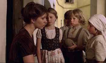 Movie still from “Woyzeck” (1979), directed by Werner Herzog – A group of children and a woman standing next to each other; Medium shot, Over the shoulder angle