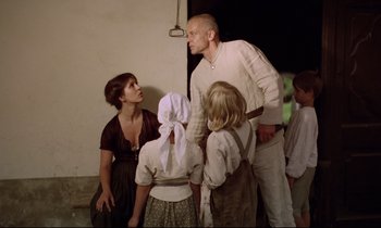 Movie still from “Woyzeck” (1979), directed by Werner Herzog – A group of people standing next to each other in a room; Medium shot, Low angle