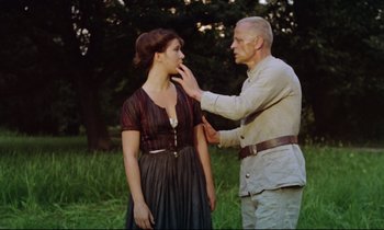 Movie still from “Woyzeck” (1979), directed by Werner Herzog – An older man touching a young woman's face outside; Medium shot, Over the shoulder angle
