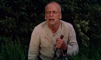 Movie still from “Woyzeck” (1979), directed by Werner Herzog – A man holding a stick in his hand; Close Up shot, Low angle