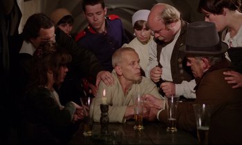 Movie still from “Woyzeck” (1979), directed by Werner Herzog – A group of people sitting around a table; Medium shot, High angle