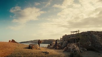 Movie still from “Wrath of the Titans” (2012), directed by Jonathan Liebesman – A man standing next to a body of water on a dirt field; Extreme Wide shot, Low angle