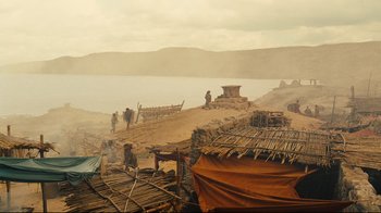 Movie still from “Wrath of the Titans” (2012), directed by Jonathan Liebesman – A group of people standing next to a body of water; Extreme Wide shot, High angle