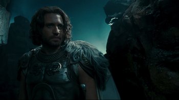 Movie still from “Wrath of the Titans” (2012), directed by Jonathan Liebesman – A person wearing a costume near another person; Close Up shot, Low angle